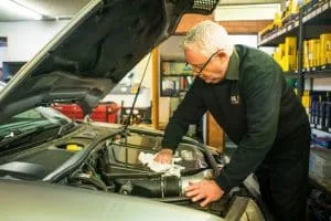 a mechanic cleaning an audi engine