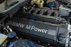 A detailed view of a BMW M Power engine, showcasing its sleek black design and mechanical components.
