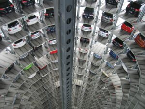 Interior view of a tall, circular automated parking garage, with multiple levels of cars stacked in a vertical tower around a central open shaft.
