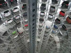 Interior view of a tall, circular automated parking garage, with multiple levels of cars stacked in a vertical tower around a central open shaft.