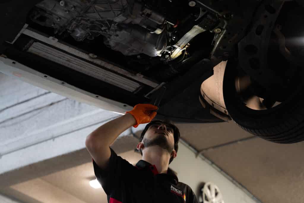 Pace Auto Werks mechanic investigating under a car