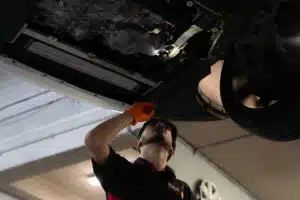 Pace Auto Werks mechanic investigating under a car