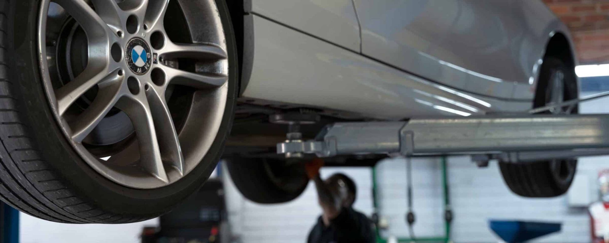 The bottom of a BMW car while elevated in a workshop